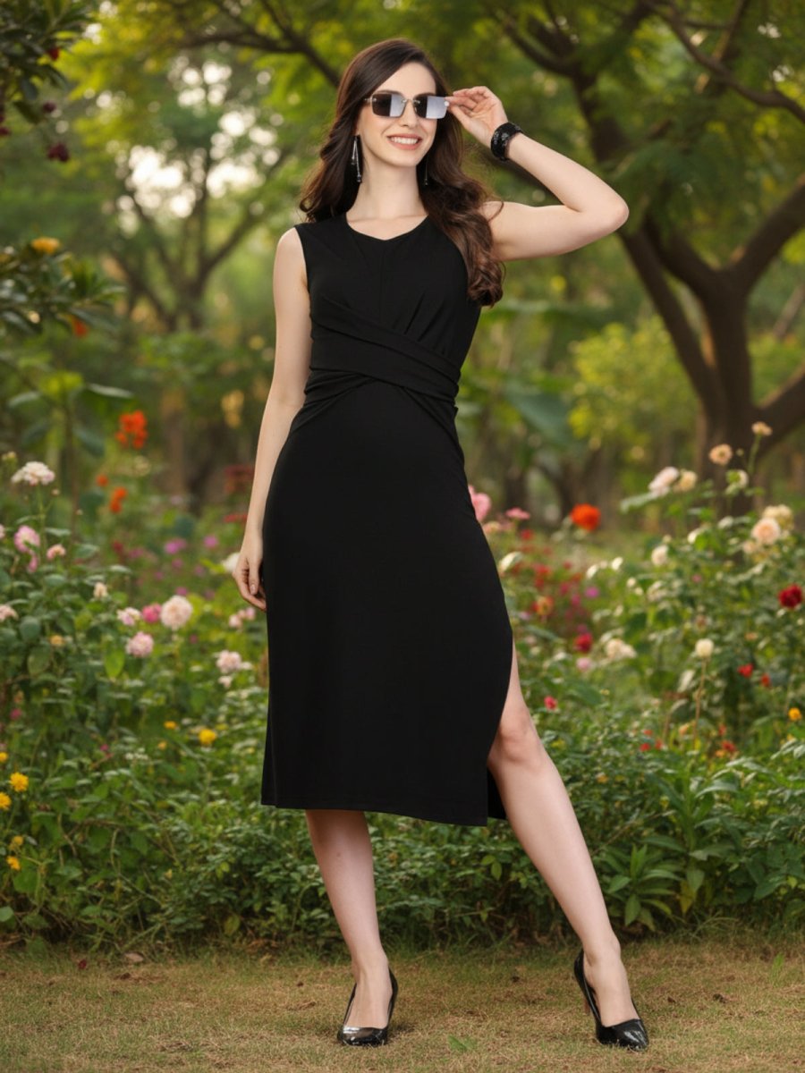 Woman in a black dress posing against a red background with a chair and vase.